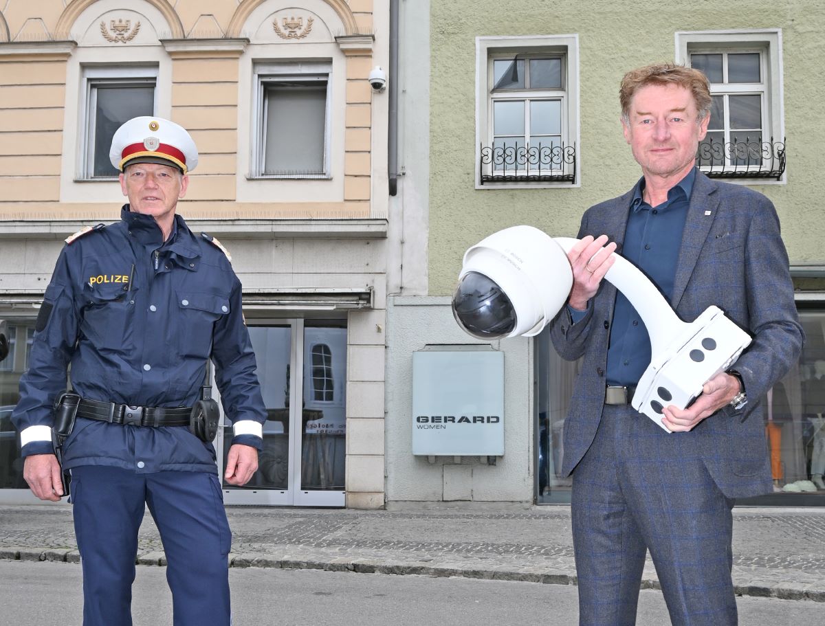 Sicherheitsreferent Vzbgm. Gerhard Kroiß hält eine Videoüberwachungskamera , neben ihm steht ein Polizist