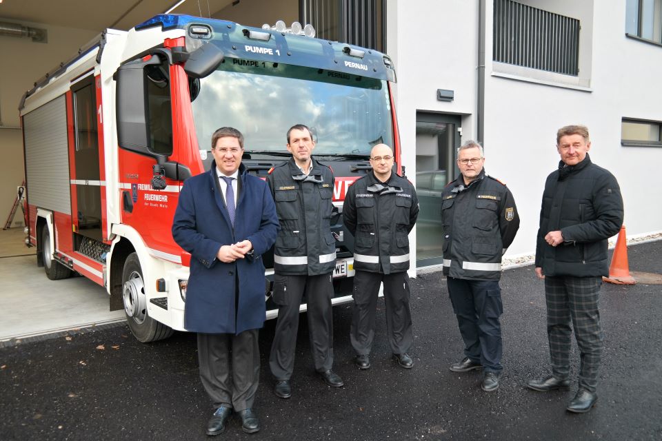 Bürgermeister Dr. Andreas Rabl und Vizebürgermeister Gerhard Kroiß stehen gemeinsam mit 3 Mitarbeitern der Feuerwehr vor dem neuen Feuerwehrfahrzeug beim neuen Gebäude der Feuerwehr in der Pernau.
