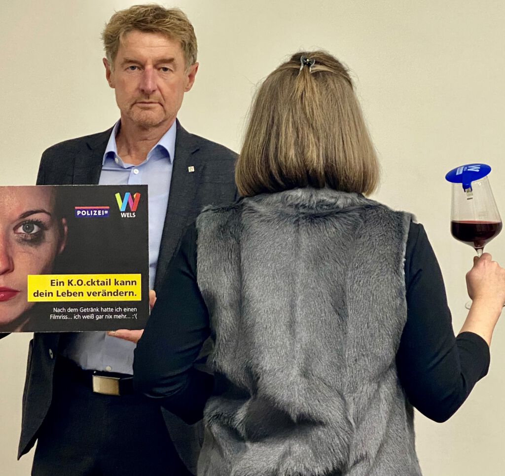 Vizebürgermeister Gerhard Kroiß mit einem Schild zur Informationskampagne gegen K.O.-Tropfen
